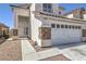 Two story home with a tile roof and stone accents, showcasing a large two-car garage and desert landscaping at 7977 Blue Brook Dr, Las Vegas, NV 89147