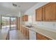 A bright kitchen featuring an island, stainless steel appliances, and sliding glass doors to the backyard at 7977 Blue Brook Dr, Las Vegas, NV 89147