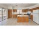 Well-lit kitchen with an island, stainless steel appliances, and sliding glass doors to the backyard at 7977 Blue Brook Dr, Las Vegas, NV 89147