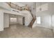 Bright, open living room with tile flooring, high ceilings, and staircase with wood railing at 7977 Blue Brook Dr, Las Vegas, NV 89147