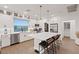 Well-lit kitchen features white cabinets, stainless steel appliances, and a large island with bar stools at 8055 Haywood Estate Ave, Las Vegas, NV 89113