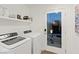 Bright laundry room equipped with modern washer and dryer, storage shelves, and convenient access to the outdoor area at 8055 Haywood Estate Ave, Las Vegas, NV 89113