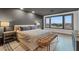 Stylish bedroom with a king bed, tufted bench, grey walls, and large scenic windows at 8055 Haywood Estate Ave, Las Vegas, NV 89113