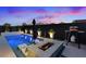 Luxurious pool area with stylish in-pool seating, a fire pit, and outdoor cooking amenities, perfect for evening relaxation at 8055 Haywood Estate Ave, Las Vegas, NV 89113