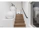 Modern staircase featuring wood steps, white walls, and minimalist design elements, creating a clean and elegant entryway at 8055 Haywood Estate Ave, Las Vegas, NV 89113