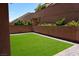 Green backyard with turf and brick-lined hardscape at 8131 Skye Plum St, Las Vegas, NV 89166
