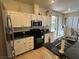 Bright kitchen featuring white cabinetry, dark countertops, stainless steel appliances, and a sliding door to the backyard at 8337 Ruby Heights Ave, Las Vegas, NV 89117