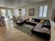 Comfortable living room with a black leather sectional sofa, rug, tile floors, and natural light from windows and sliding glass doors at 8337 Ruby Heights Ave, Las Vegas, NV 89117