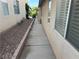 Narrow side yard with gravel ground cover, windows and concrete walkway at 8337 Ruby Heights Ave, Las Vegas, NV 89117