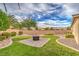 Professionally landscaped backyard with manicured lawn, decorative landscaping, and custom fire pit area at 8633 Kennedy Heights Ct, Las Vegas, NV 89131