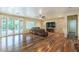 Spacious living room with wood flooring, a ceiling fan, a stone accent wall, and access to the outdoors at 8633 Kennedy Heights Ct, Las Vegas, NV 89131