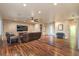 Spacious living room boasts a beautiful brick wall, dark wood floors, and modern ceiling fan at 8633 Kennedy Heights Ct, Las Vegas, NV 89131