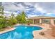 Backyard oasis with a freeform pool, mature landscaping, and outdoor kitchen is perfect for entertaining at 8633 Kennedy Heights Ct, Las Vegas, NV 89131
