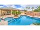 Sparkling pool with surrounding deck features a lush tropical landscaped yard and outdoor kitchen at 8633 Kennedy Heights Ct, Las Vegas, NV 89131