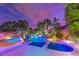 An inviting pool and spa are surrounded by lush tropical landscaping and ambient lighting at 8633 Kennedy Heights Ct, Las Vegas, NV 89131