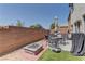 Backyard patio with seating, an umbrella, a firepit, and brick wall at 9091 Jumping Jacks Ave, Las Vegas, NV 89178