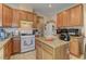 Bright kitchen featuring granite countertops, an island and wood cabinets at 9091 Jumping Jacks Ave, Las Vegas, NV 89178