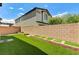 Backyard featuring a brick wall and green turf with blue skies above at 934 Twincrest Ave, North Las Vegas, NV 89032