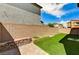 Backyard featuring turf, brick landscaping, and a privacy wall, with blue skies above at 934 Twincrest Ave, North Las Vegas, NV 89032