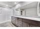 This modern bathroom features a double vanity, a large mirror, a tiled floor and a glass shower at 934 Twincrest Ave, North Las Vegas, NV 89032