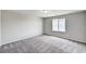 Bright bedroom features neutral walls, plush gray carpet, and a window providing natural light at 934 Twincrest Ave, North Las Vegas, NV 89032