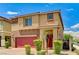 Inviting two-story home with a red front door and colorful landscaping, featuring a brick driveway at 934 Twincrest Ave, North Las Vegas, NV 89032