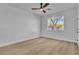 Bright, empty bedroom with a ceiling fan and view of a tree at 10200 Wood Work Ln, Las Vegas, NV 89135
