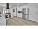 Open kitchen featuring white cabinetry, stainless steel appliances, wine rack, and wood-look flooring at 10200 Wood Work Ln, Las Vegas, NV 89135