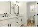 Modern bathroom featuring double sinks, white cabinets, black hardware, and a separate toilet room at 10302 Artful Stone Ave, Las Vegas, NV 89149