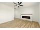Bright living room with wood floors, ceiling fan, and a modern electric fireplace at 10302 Artful Stone Ave, Las Vegas, NV 89149
