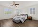 Bright bedroom with white walls, wood floors, ceiling fan, and shuttered windows at 10368 Mystic Pine Rd, Las Vegas, NV 89135