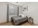Cozy bedroom with a modern vibe, featuring wood-look floors and a large window for natural light at 10368 Mystic Pine Rd, Las Vegas, NV 89135