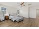 Bright bedroom with white walls, wood floors, ceiling fan, and shuttered windows at 10368 Mystic Pine Rd, Las Vegas, NV 89135
