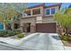 Two-story home featuring a two-car garage, a porch, and desert landscaping at 10368 Mystic Pine Rd, Las Vegas, NV 89135