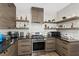 Modern kitchen boasts stainless steel appliances, granite countertops, and sleek wood-grain cabinets at 10368 Mystic Pine Rd, Las Vegas, NV 89135