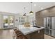 Beautiful kitchen with an island and counter seating, stainless steel appliances, and modern pendant lights at 10368 Mystic Pine Rd, Las Vegas, NV 89135