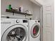 Convenient laundry room featuring a washer and dryer and a storage shelf above at 10368 Mystic Pine Rd, Las Vegas, NV 89135