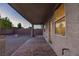 A covered patio area made of decorative brick pavers with a gravel backyard and a tree at 1037 Water Cove St, Henderson, NV 89011