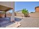 A spacious backyard features low-maintenance desert landscaping, a brick patio, and a charming decorative tree at 1037 Water Cove St, Henderson, NV 89011