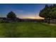 A lush green space with a walking path and trees against a twilight mountain backdrop at 1037 Water Cove St, Henderson, NV 89011
