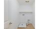 A clean laundry room with tile flooring, shelving, and hookups ready for washer and dryer installation at 1037 Water Cove St, Henderson, NV 89011