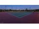 Nighttime view of well-lit tennis courts with green and red surfaces in a community setting at 1037 Water Cove St, Henderson, NV 89011