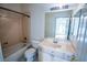 Bathroom features a tub-shower, toilet, and a vanity sink with a large mirror, bright overhead lighting and tile flooring at 105 Chateau Whistler Ct, Las Vegas, NV 89148