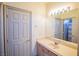 Well-lit bathroom featuring a large mirror, a single sink vanity, and a visible doorway to an adjacent room at 105 Chateau Whistler Ct, Las Vegas, NV 89148
