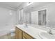 Well-lit bathroom with double sinks, tub and shower with decorative mirror at 1063 Silver Star St, Henderson, NV 89002