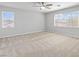 Spacious bedroom with carpet, ceiling fan, and two large windows at 1063 Silver Star St, Henderson, NV 89002