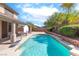 Sparkling backyard pool area with convenient basketball hoop, lush plants and covered patio at 1063 Silver Star St, Henderson, NV 89002