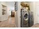 Laundry with front loading washer and dryer, built in shelving, and dining room view at 10638 La Spezia Way, Las Vegas, NV 89141