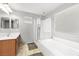 Bright bathroom with a soaking tub, glass-enclosed shower, and a large window with natural light at 1165 Cactus Rock St, Henderson, NV 89011