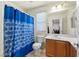 Bright bathroom with a vanity, toilet, and a bathtub with a blue patterned shower curtain at 1165 Cactus Rock St, Henderson, NV 89011